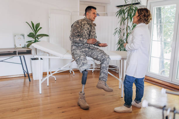 istock Therapist in white coat talking with military veteran with a prosthetic leg 2164332106