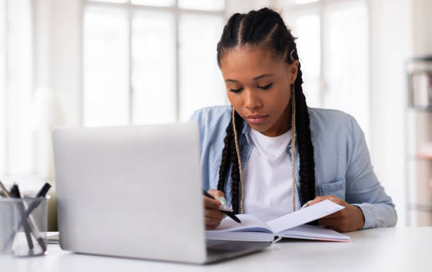 istock Dedicated female student focusing on her studies with laptop 2164333718