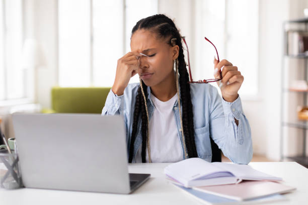 istock Stressed black lady student with headache studying at laptop 2164333721