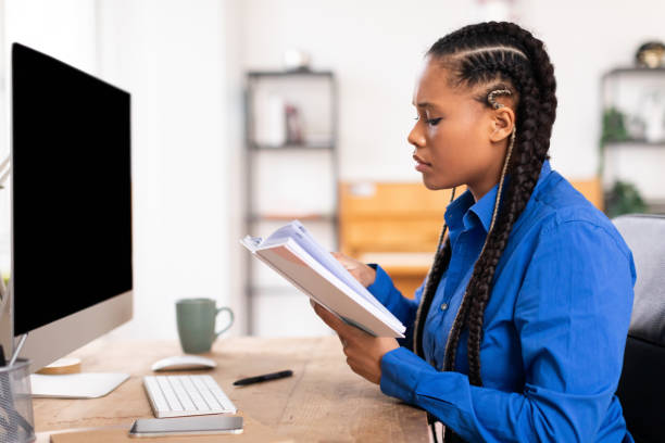 Serious female student reading textbook at her desk