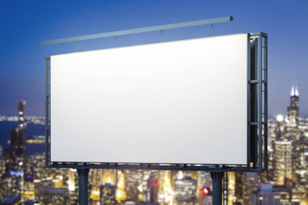 istock Blank white horizontal billboard on city buildings background at night, perspective view. Mockup, advertising concept 2164335647
