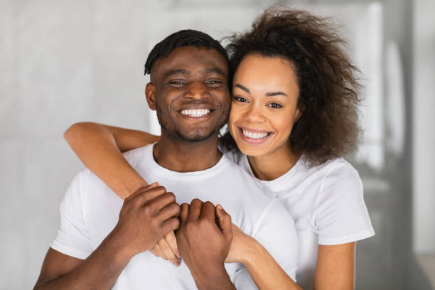 istock Happy African American couple in bathroom posing affectionately embracing 2164336324