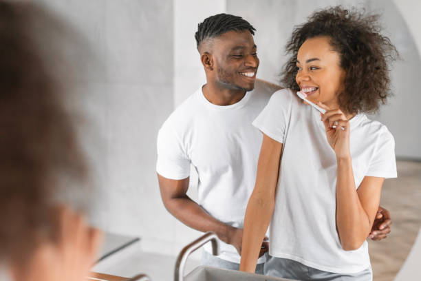 istock black husband hugs wife as she brushing teeth in bathroom 2164336402