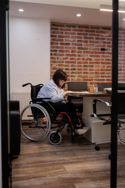 istock Woman with a disability working in an office 2164336512