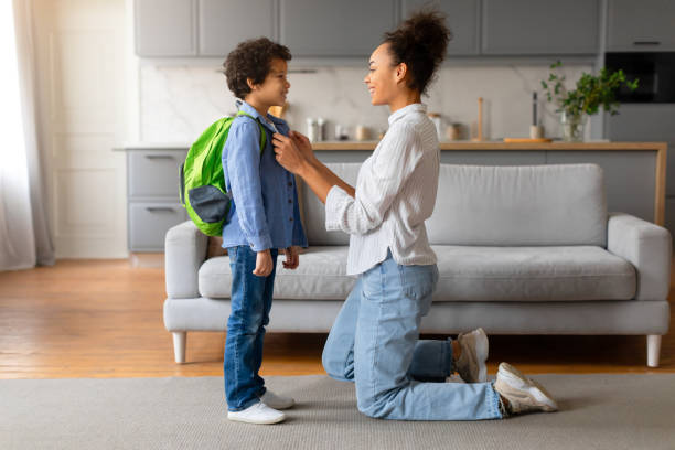 istock Mother adjusting son's backpack before school in living room 2164339076