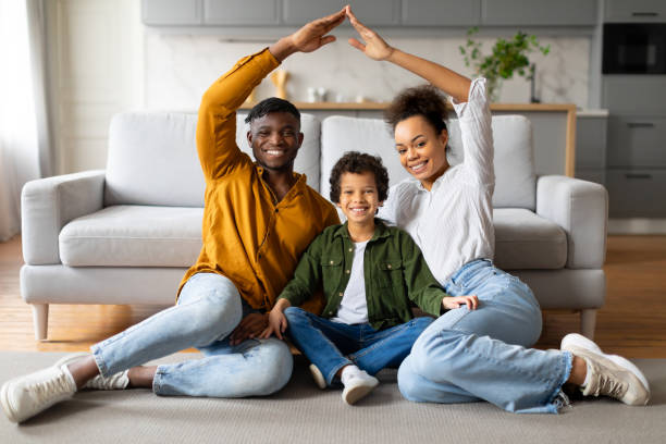 istock Joyful black family making house shape with hands at home 2164339100
