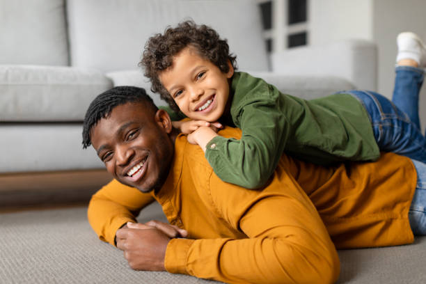 istock Black father and son share playful moment on the floor 2164339105