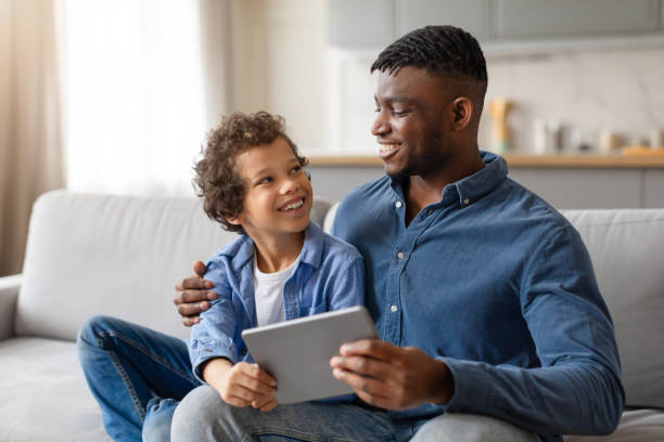 istock African american father and son sharing digital tablet, looking happy 2164339192