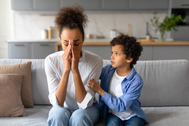 Mother distressed with son showing empathy Worried mother with her comforting son in a living room, emotions on display worried mom with kids stock pictures, royalty-free photos & images