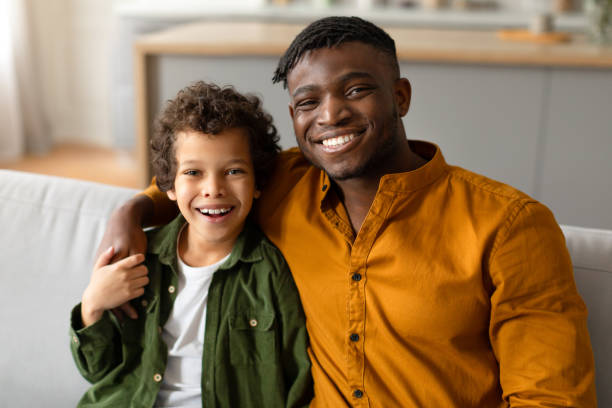istock Father and son smiling and embracing at home 2164339223