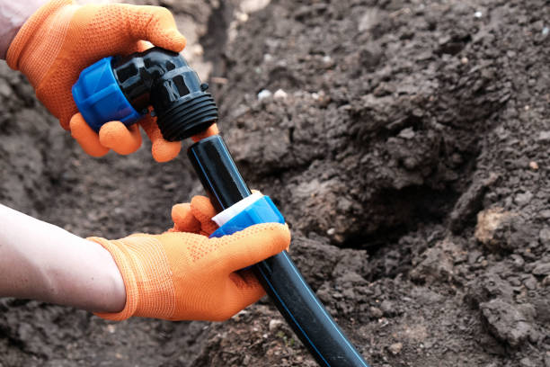 istock master plumber installs a water supply system from HDPE pipes, installs a compression fitting at an angle bend, hands close-up 2164341265
