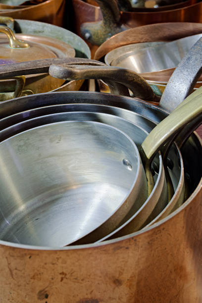 Big group of stacked classic copper saucepans. Abstract vintage kitchenware background.
