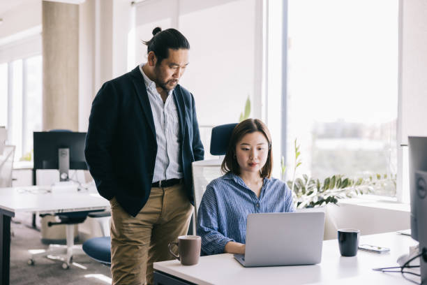 istock Two Japanese colleagues working together at the office 2164341810