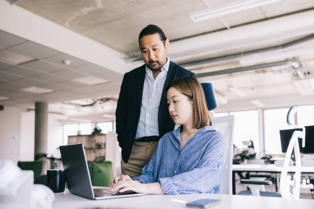 istock Two Japanese colleagues working together at the office 2164341814