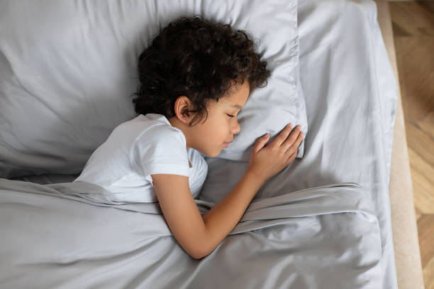 istock Small Child Laying in Bed With Pillow 2164343065