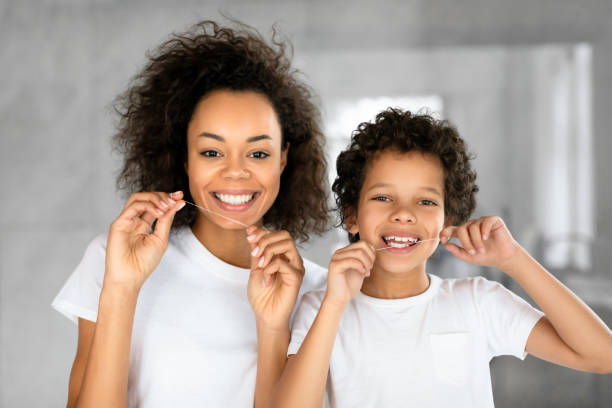 Mother and Son Practicing Dental Hygiene With Bright Smiles