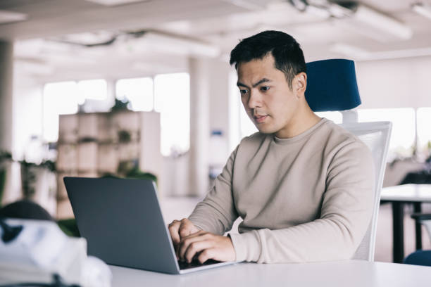istock Young Asian man working on his laptop at the office 2164345848