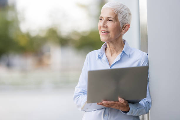 istock Confident Senior Woman Embracing Technology with Laptop 2164348466
