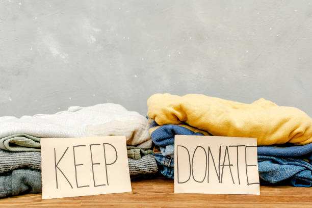 istock Stack of old baby children clothes sorted into Keep and Donate categories.Donation,volunteering help,humanitarian aid.charity on gray background still life.Recycle clothing,eco cotton 2164348561
