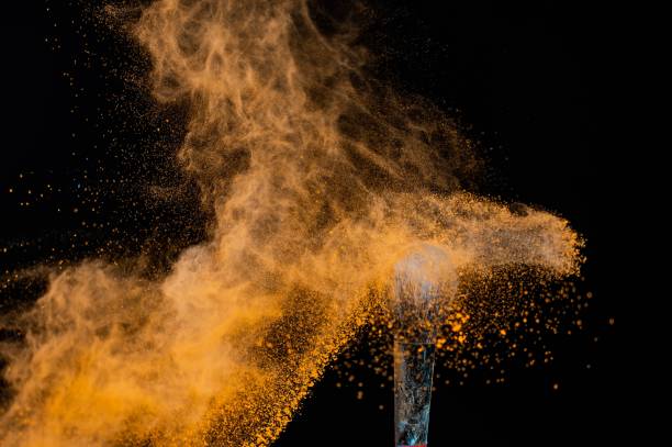 istock A wide brush sprays orange powder on a black background. 2164348800
