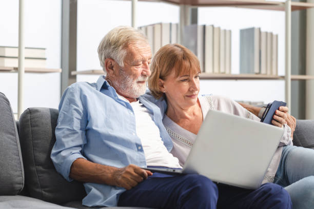 istock Man and woman using digital tablet and labtop read document information at home, Senior couple in living room 2164354604