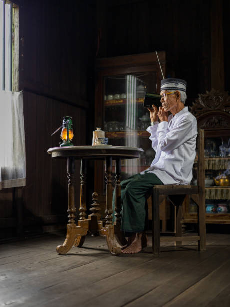 A grandfather is listening to the radio