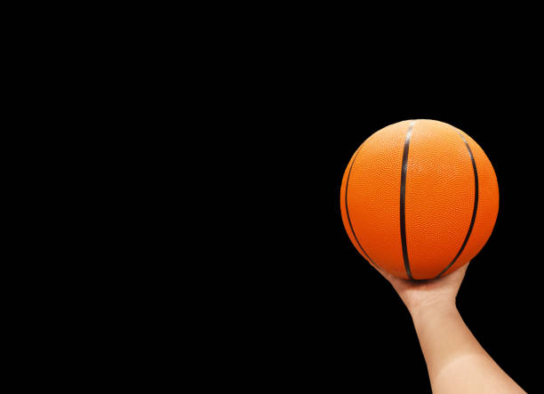 istock Basketball ball in hand isolated on black background. 2164358871