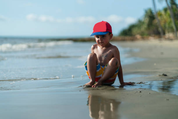 istock boy walking on the beach alone during a beautiful morning 2164359227