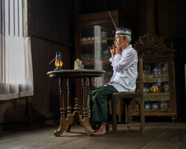 A grandfather is listening to the radio