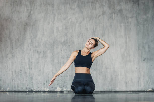istock Young woman doing neck stretching exercise. Stretching and relaxation to improve strength and tone. Healthy lifestyle and wellbeing background 2164370052