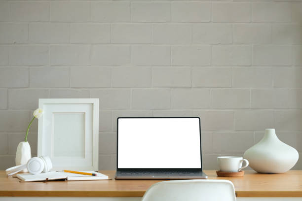 istock Workplace comfortable with computer laptop, coffee cup, notebook, picture frame and flower pot. 2164371635