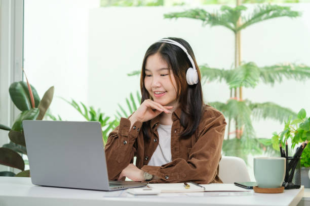 istock Pretty young creative woman with wireless headphone using laptop, working on design project in modern office. 2164372161