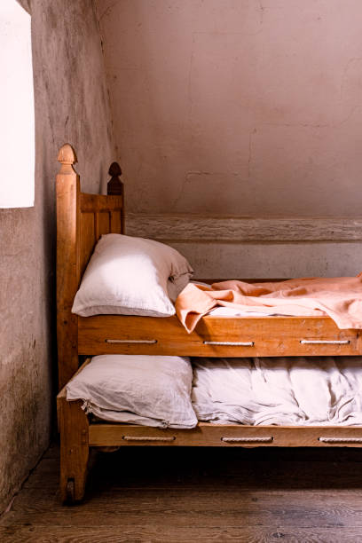 An empty bed  and bed frame sit in an abandoned house in the old gold mining town of Bodie, California.  A reminder of days gone by, the bedroom stands frozen in time.