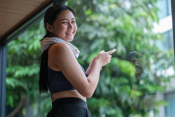 istock Smiling young sportswoman using smartphone at gym while relaxing after training. 2164374969