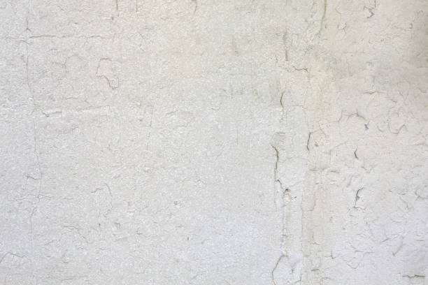 Close-up of a textured cracked white wall. Abstract grunge surface.