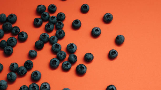 istock Tasty ripe blueberries on orange background, flat lay with space for text 2164377046