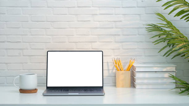 istock Minimalist home office setup showcasing a sleek laptop with a blank white screen, perfect for adding your own content. The workspace features a clean. 2164380830