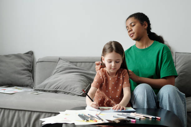 istock Cute little child drawing next to sitter 2164383378