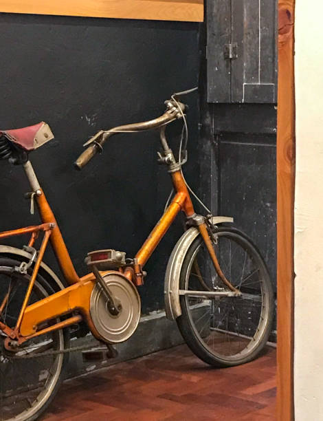 old orange bicycle leaning on a wall