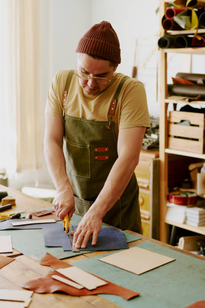 istock Male Tailor Using Round Knife to Cut Out Details 2164387431