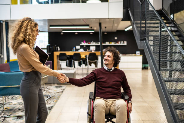 istock Young colleagues greeting each other while having meeting in office hall 2164389137