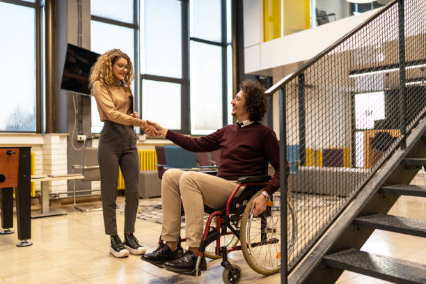 istock Young colleagues greeting each other while having meeting in office hall 2164389250