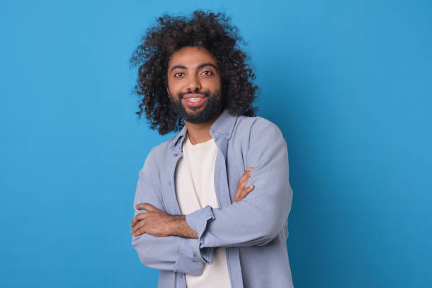 istock Joyful Man With Curly Hair Posing Against a Vibrant Blue Background 2164393253