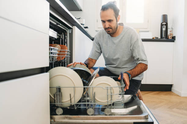 istock Man emptying the dishwasher in a modern kitchen 2164393509