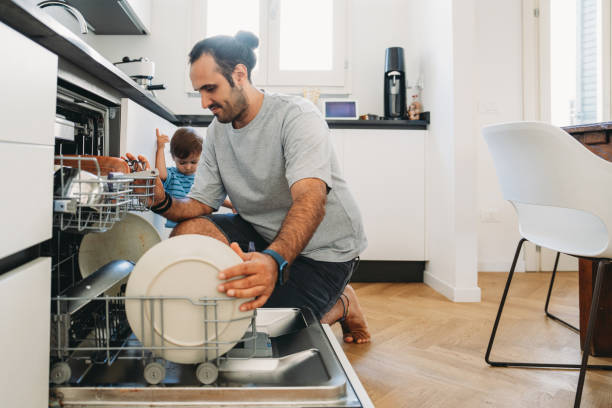 istock Young father loading dishwasher with toddler son helping 2164393525