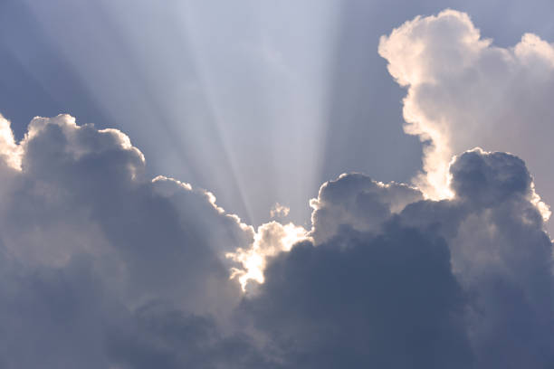 Blue-white cumulus clouds in the rays of the sun. Thunderstorm clouds.