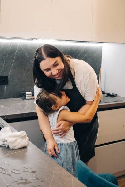istock A Heartwarming and Touching Moment Shared Between a Loving Mother and Her Child in a Cozy Kitchen. Happy family enjoys moments of cooking at home. 2164397211