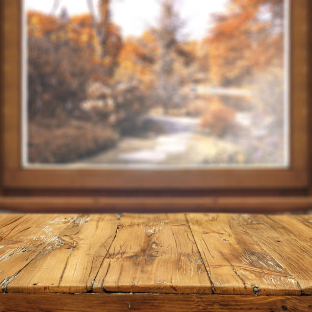 istock Wooden table with empty copy space for products. Window background overlooking blurred autumn garden. Image can be used for display or montage your products. 2164397565