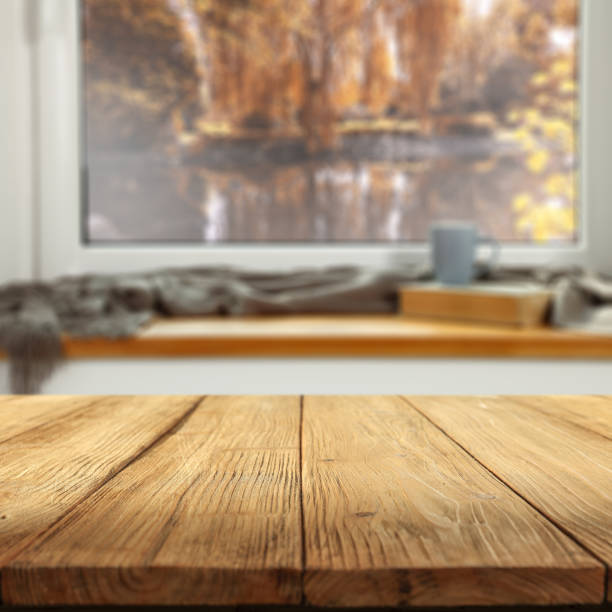 istock Wooden table with empty copy space for products. Window background overlooking blurred autumn garden. Image can be used for display or montage your products. 2164397579