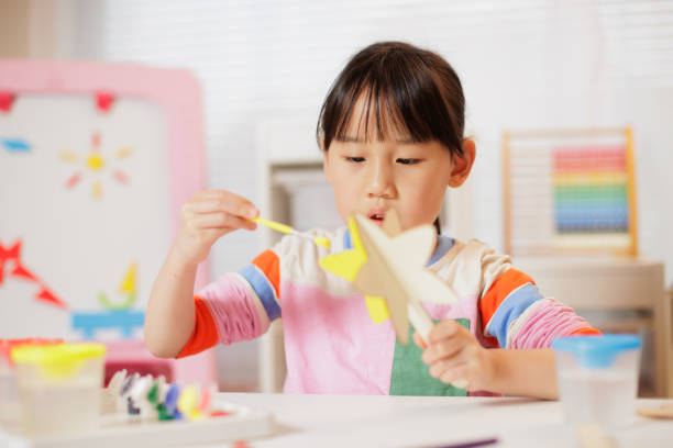 young girl making craft at home